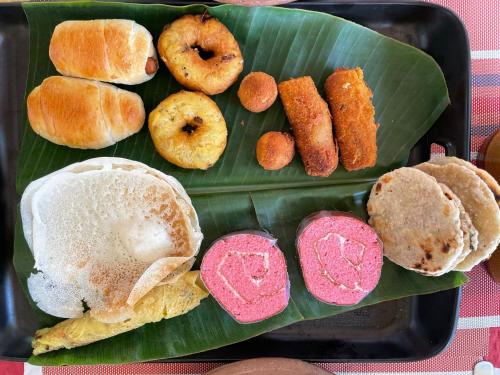 - un plateau de différents types de pâtisseries sur une feuille de bananes dans l'établissement Sigiriya Water Guest & View Point Restaurant, à Sigirîya