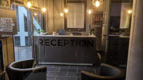 a reception desk with two chairs in a restaurant at BUSINESS-MOTEL, free XL-Parking, eCharging, Self Checkin, Massage, Sauna in Heimsheim