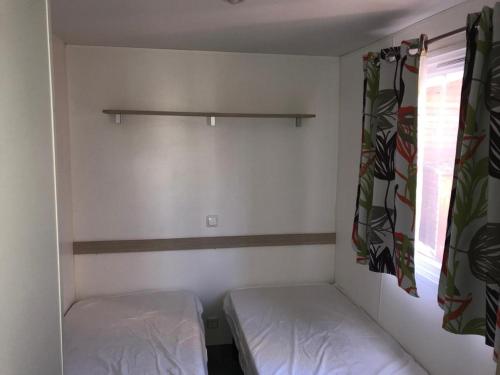 mały pokój z 2 łóżkami i oknem w obiekcie Mobil Home Chamonix/Mont Blanc M043 w mieście Passy