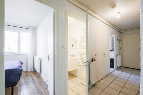 - une chambre avec un lit et une porte menant à un couloir dans l'établissement T4 spacieux tout confort / parking gratuit, à Grenoble