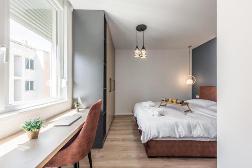 um quarto com uma secretária, uma cama e uma janela em Amazing seaview apartment with jacuzzi em Durrës