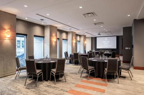 a conference room with tables and chairs and a screen at Delta Hotels by Marriott Vancouver Downtown Suites in Vancouver
