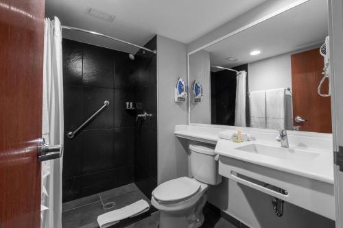 a bathroom with a toilet and a sink and a shower at City Express Plus by Marriott Guadalajara Expo in Guadalajara