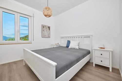 - une chambre blanche avec un lit et une fenêtre dans l'établissement Lake View Luca Apartment, à Malcesine