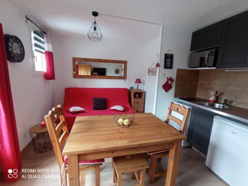 a small kitchen with a table and a red couch at Appartement à Puy Saint Vincent 1700 in Puy-Saint-Vincent