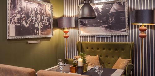 a dining room with a table and chairs and pictures on the wall at Srebrny Bucznik Wellness & Restaurant in Istebna