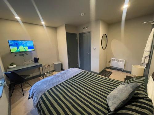 um quarto com uma cama, uma secretária e uma televisão em CV1 City Stays - Short & Long Term Accommodation No.6 em Coventry