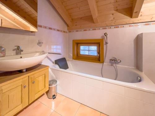 een badkamer met een wastafel en een bad bij 1A Chalet Koralpenzauber - Wandern, Sauna, Grillen mit Traumblick in Wolfsberg