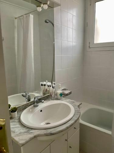 a bathroom with a sink and a tub and a mirror at RichMarHome in Pego