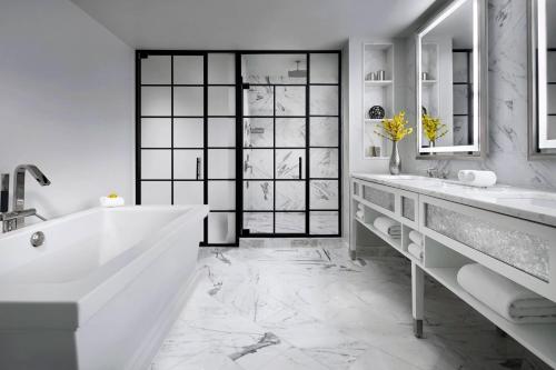 a white bathroom with two sinks and a tub at The Ritz-Carlton, Tysons Corner in Tysons Corner