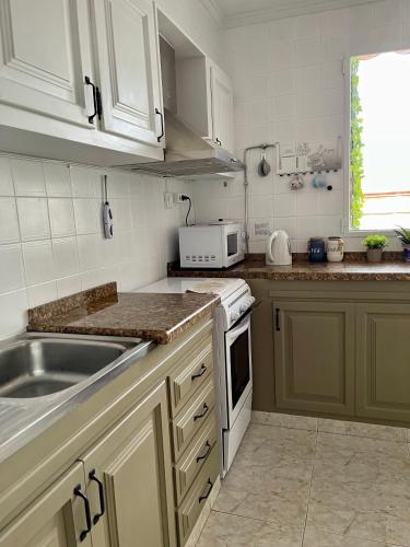 a kitchen with a sink and a stove top oven at RichMarHome in Pego