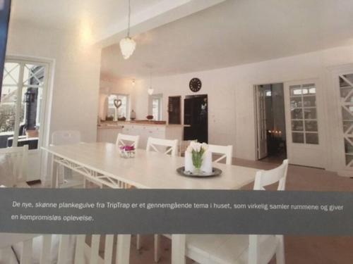 赫斯霍爾姆的住宿－Eksklusivt hus på 250 m2 i naturskønne omgivelser，厨房以及带白色桌椅的用餐室。