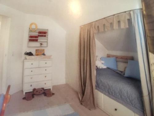 - une chambre avec un lit à baldaquin et une commode blanche dans l'établissement Eksklusivt hus på 250 m2 i naturskønne omgivelser, à Hørsholm