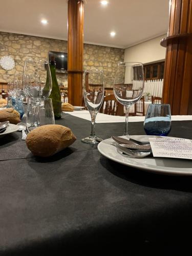 a table with wine glasses and a plate on it at Hotel Restaurante Benidorm 1970 in Villamayor