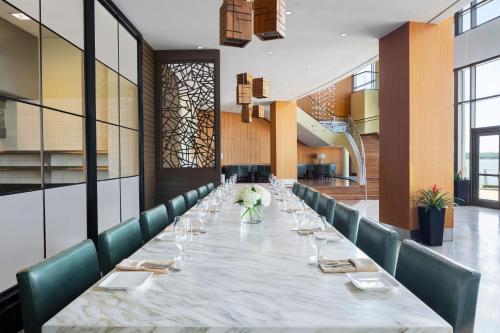 a long dining room with a long table and green chairs at The Westin Washington National Harbor in National Harbor