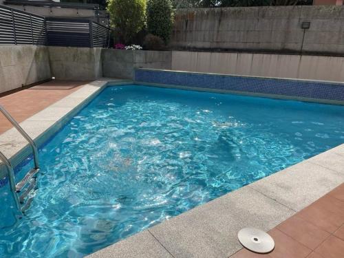 a swimming pool with blue water in a yard at Recuncho Costeiro in Baiona