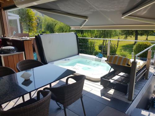 une terrasse avec une table et des chaises ainsi qu'une piscine dans l'établissement Joli Bungalow & Spa, à Portalban- Dessous