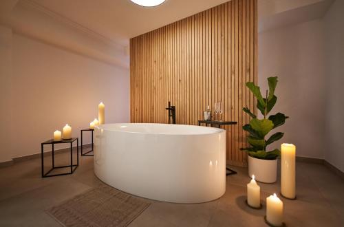baño con bañera blanca y velas. en Hotel Neuhäusl Superior, en Berchtesgaden