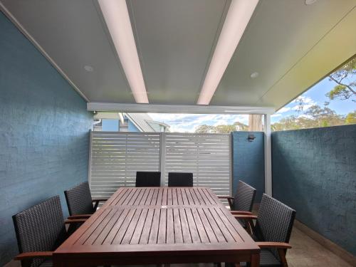 a table and chairs in a room with a window at Blue Lago at Raffertys Resort in Cams Wharf