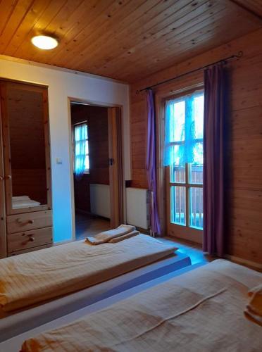 1 dormitorio con 2 camas y ventana en Ferienhaus Himmelreich en Seebenstein