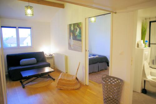 uma sala de estar com um sofá e um quarto em Maison de charme au Mont Valérien avec jardin privatif em Nanterre