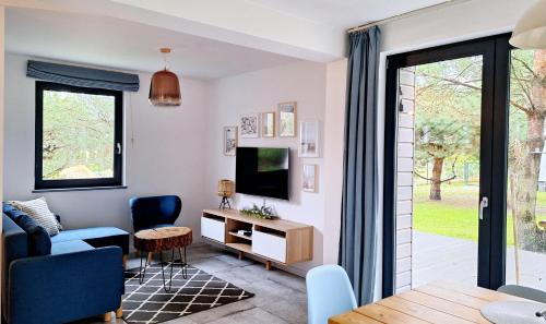 uma sala de estar com uma televisão, um sofá e uma mesa em Sosnowe Zacisze em Sasino