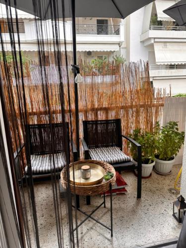 a patio with a table and two chairs and an umbrella at Lovely private room in fancy neighborhood in Athens