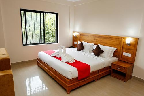 Un dormitorio con una cama grande y una ventana en Jet Paark, en Sultan Bathery