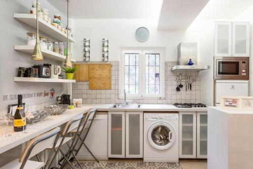 a white kitchen with a washing machine in it at Cozy house at Vatican/StPeter's dome shade. in Rome
