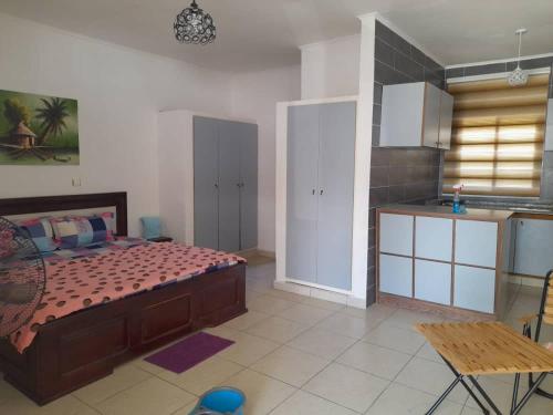 1 dormitorio con 1 cama grande y cocina en Namaste hotel & restaurant en Libreville