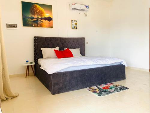 Un dormitorio con una cama con almohadas rojas. en Namaste hotel & restaurant en Libreville