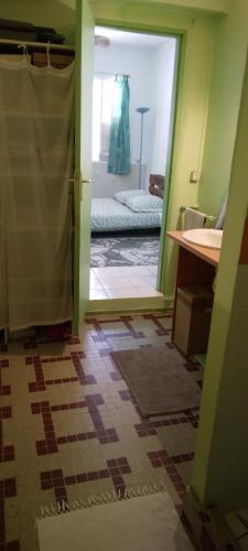 a bathroom with a door open to a room with a bed at Chambre d'hôtes pieds dans l'eau in Grande Anse