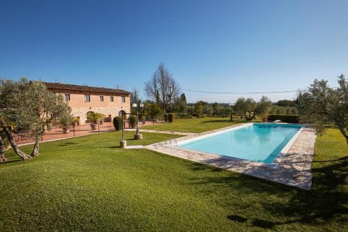 a large swimming pool in a yard next to a building at Agriturismo Podere Casato in Castelnuovo Berardenga