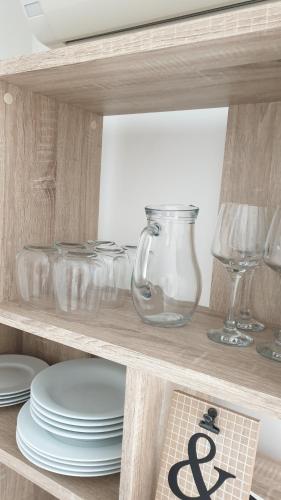 a wooden shelf with plates and glasses on it at Appartement LE BOIS FLOTTE in Saintes-Maries-de-la-Mer