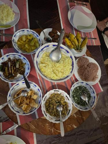 a table full of bowls of food with spoons at Sigiriya Water Guest & View Point Restaurant in Sigiriya