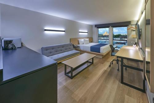 a room with a kitchen and a living room with a couch at City Express by Marriott Cancun Aeropuerto in Cancún