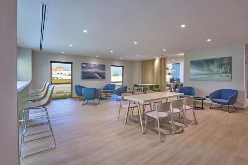 a waiting room with a table and chairs at City Express by Marriott Cancun Aeropuerto in Cancún