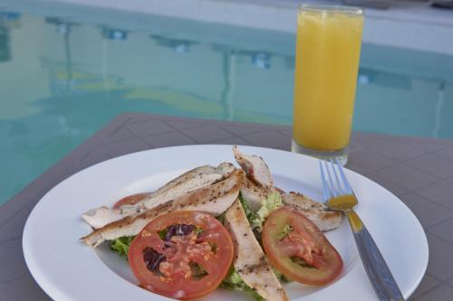 a plate with a sandwich and a glass of orange juice at City Express by Marriott Cancun Aeropuerto in Cancún