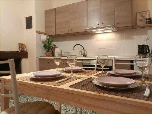 eine Küche mit einem Holztisch mit Tellern und Weingläsern in der Unterkunft Moka's house 