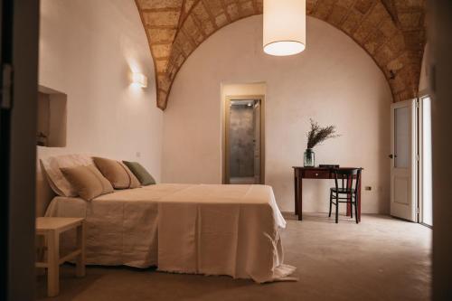 a bedroom with a bed and a table in a room at Palazzo Pati in Tiggiano