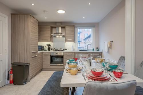 a kitchen with a table with bowls and plates on it at Belfast City Centre - 3 bed, 3 bathroom & parking by StayByNumbers in Belfast