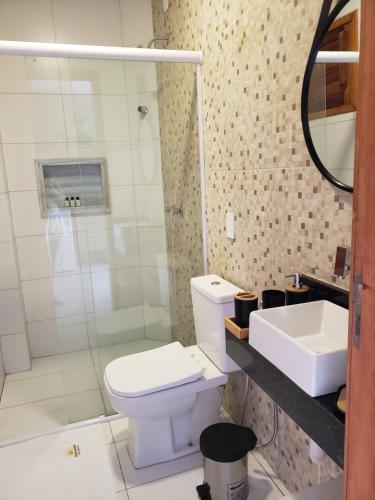 a bathroom with a toilet and a sink and a shower at Zaya Beach Residence in Icaraí