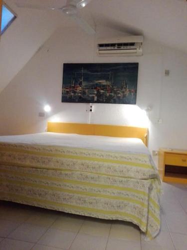 een slaapkamer met een bed met een gele deken erop bij Villetta a Schiera Calaverde in Fort Village