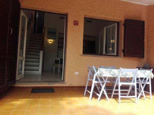 een tafel en stoelen op een veranda met een raam bij Villetta a Schiera Calaverde in Fort Village