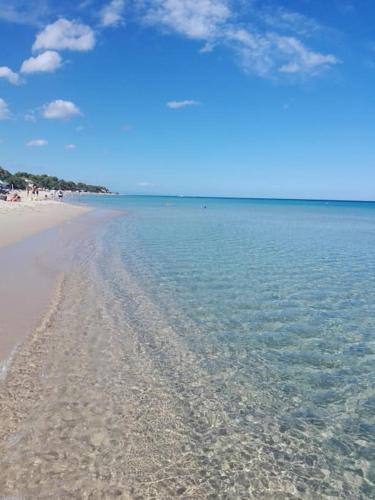una playa de arena con vistas al océano en Villetta a Schiera Calaverde, en Fort Village