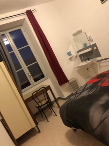 ein Schlafzimmer mit einem Fenster, einem Bett und einem Stuhl in der Unterkunft rest'hôtel chambre N3 in Augé