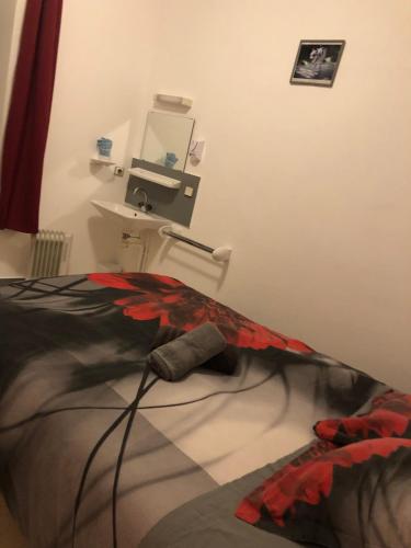 een slaapkamer met een bed en een wastafel in een kamer bij rest'hôtel chambre N3 in Augé
