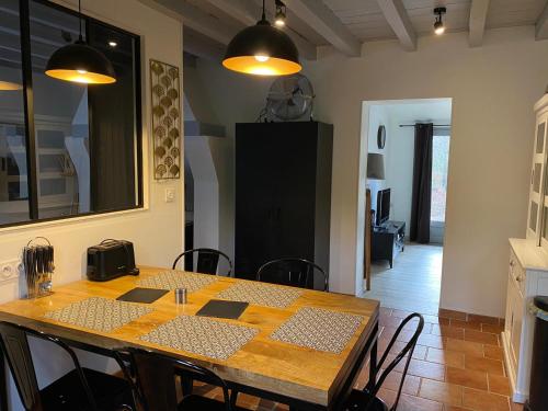 a dining room with a wooden table and chairs at Gîtes & Spa de charme " Ploum" in Pouydesseaux
