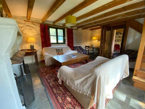 a bedroom with two beds and a table in a room at The Barn, Higher Boden, Manaccan, Helston, Cornwall in Helston