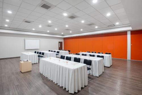 a room with white tables and chairs and a whiteboard at City Express by Marriott Silao Aeropuerto in Silao